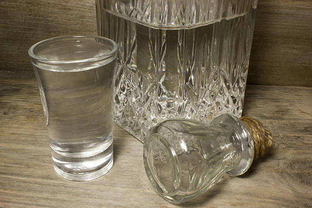 istock Glass of vodka on wooden table 538893204