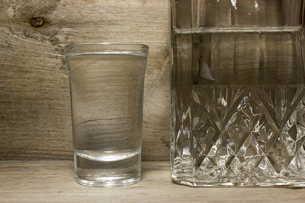 istock Glass of vodka on wooden table 538893284