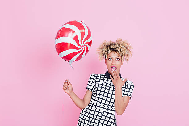 istock Afro American young woman holding candy balloon 538899228