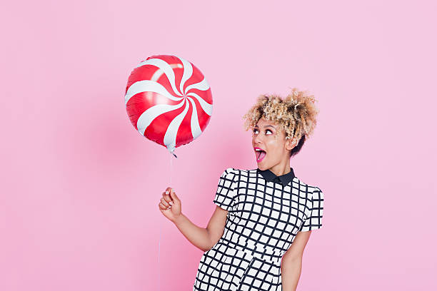 istock Afro American young woman holding candy balloon 538899342
