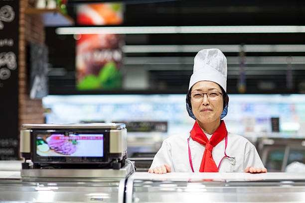 女性スタッフは、デリカテッセンのスーパーマーケット - supermarket sales clerk grocer apron ストックフォトと画像