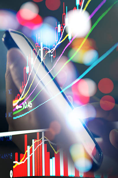 istock cell phone on hand with stock market data background 538901265