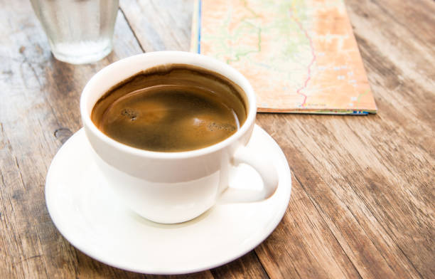 istock Coffee cup,map,Glass water on wooden table.Poor light background 538901750