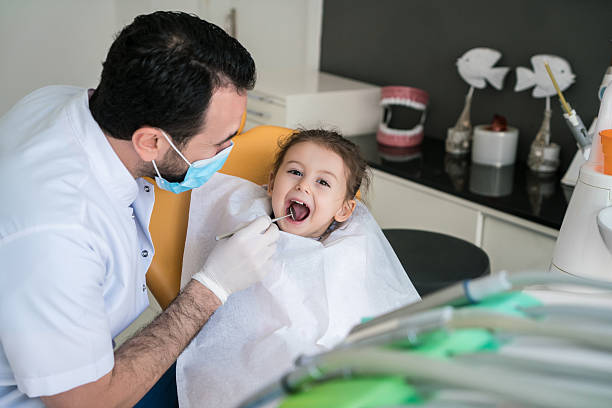 ハッピーな幼児の女の子の彼女の歯が迫力の歯科医のオフィスにお問い合わせください。 - dentist dentists chair men confidence ストックフォトと画像