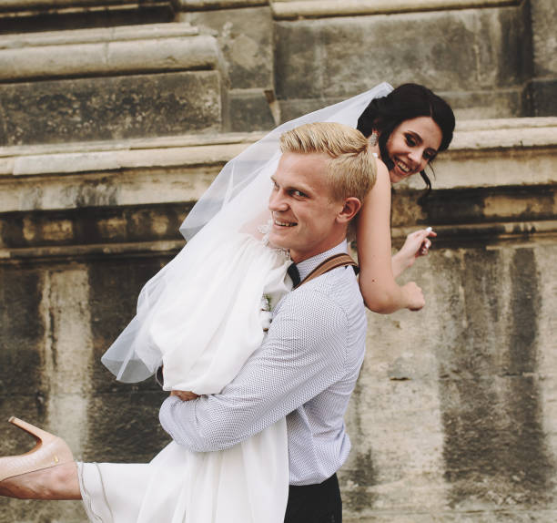 istock groom carries bride in his arms 538903926