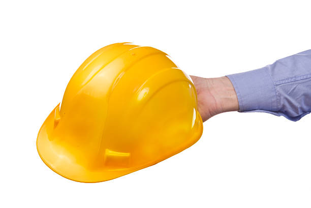 istock Male worker's hand holding yellow industrial protective helmet. 538904453