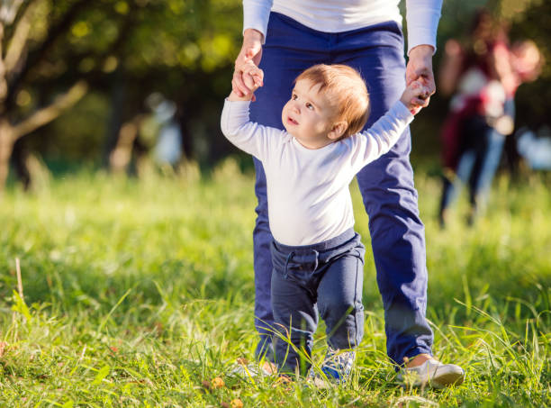 istock Mother holding hands of her son making first steps 538906880