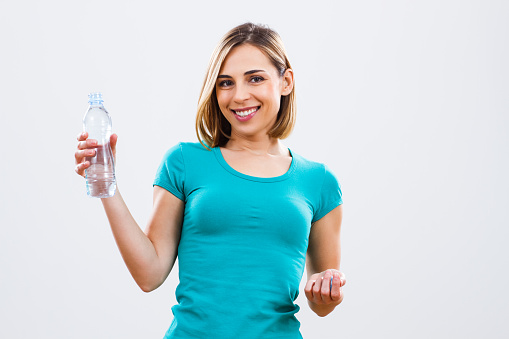 Beautiful woman is holding bottle of water.