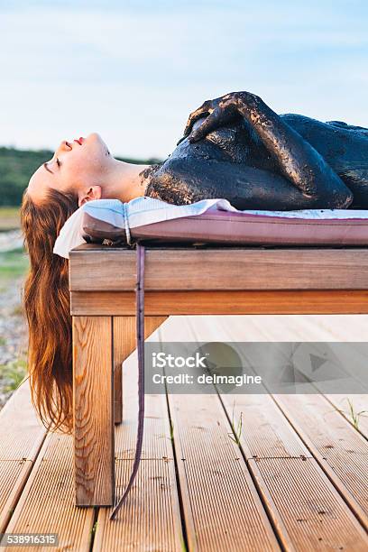 Woman Sludge Treatment During Sunset Stock Photo - Download Image Now - Beauty Spa, Spa Treatment, Tourist Resort