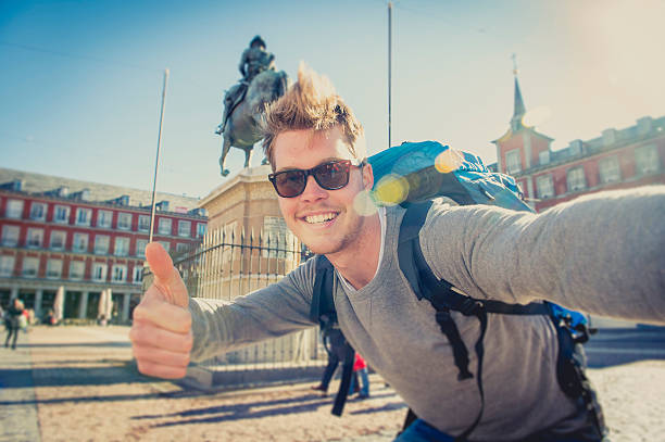 student backpacker tourist taking selfie photo with stick and mobile stock photo