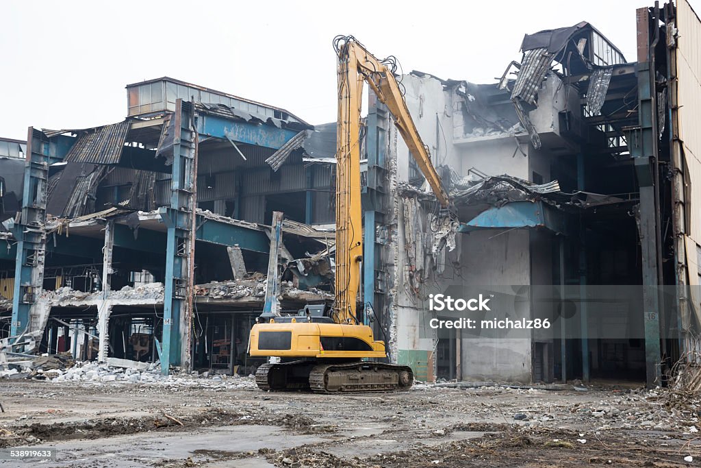 Bulldozer crushing the building at construction site Demolition of the old factory building. Poland Construction Industry Stock Photo