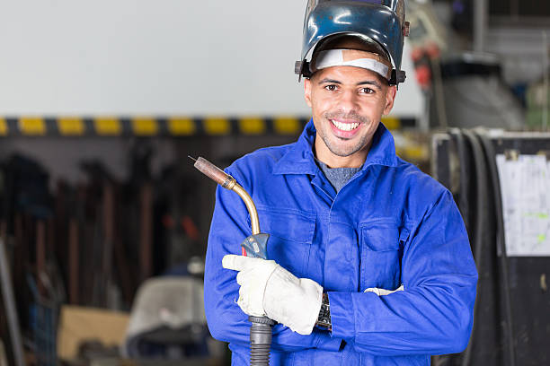 professionelle schweißer posieren mit wellding machine - welder manual worker african descent steel worker stock-fotos und bilder