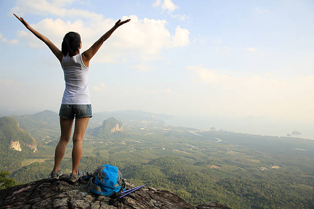 istock cheering hiking woman on mountain peak 538928063
