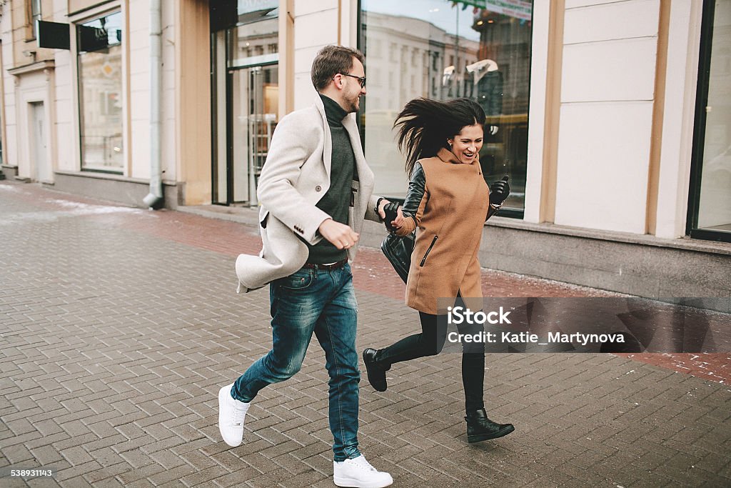 Young fashionable couple walks the city streets in winter Young fashionable couple walks the city streets in winter hand in hand 2015 Stock Photo