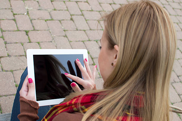 istock Woman on bench holding tablet 538931151
