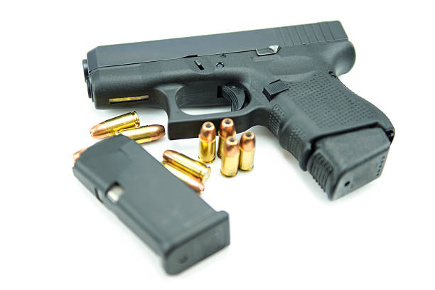 istock Black gun and 9mm bullets isolated a white background. 538965633
