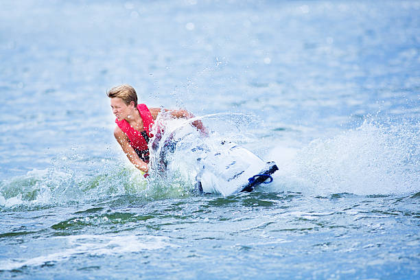 A teen boy having fun on jet ski boat.