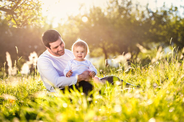 istock Father holding his little son, sitting on the grass 538981356