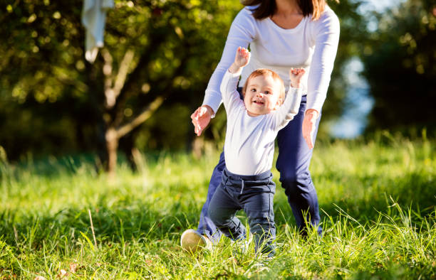 istock Mother mother her son making first steps, sunny nature 538981796