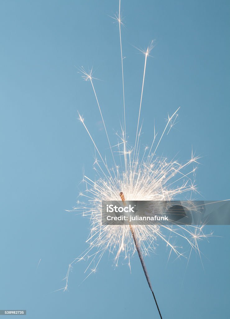 Sparkler Close up of a burning sparkler on a blue background Sparkler - Firework Stock Photo