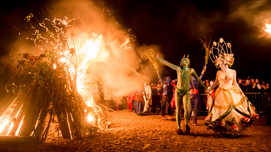Edinburgh, UK - May 1, 2016: The May Queen and the Green Man dance after lighting the bonfire during the 2016 Beltane Fire Festival on Calton Hill in Edinburgh.