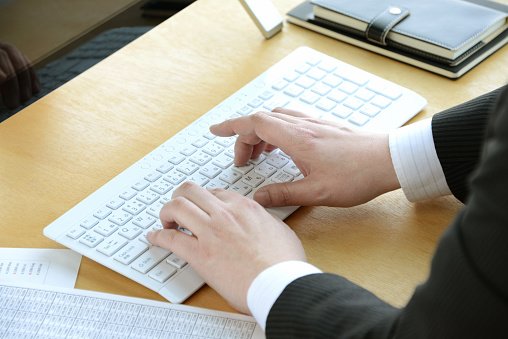 Businessman's hand using laptop in office