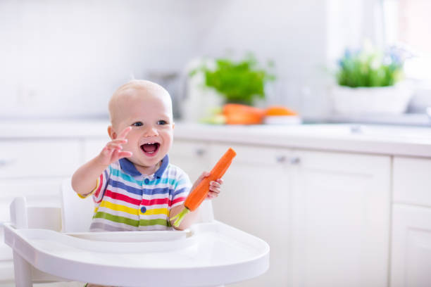 istock Adorable little baby eating carrot 538991284