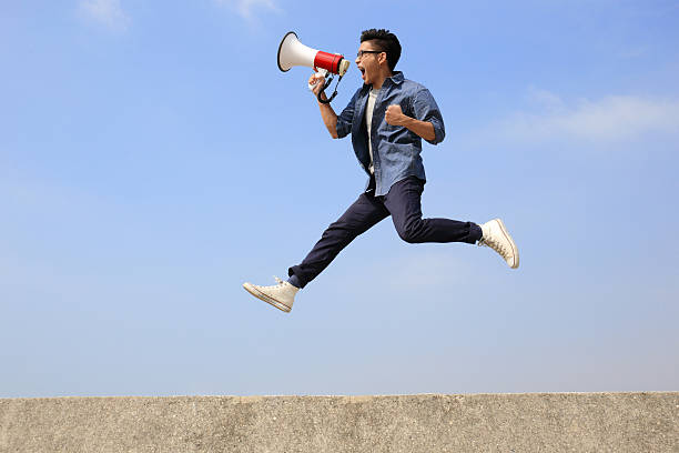 istock man jump and shout megaphone 538992113