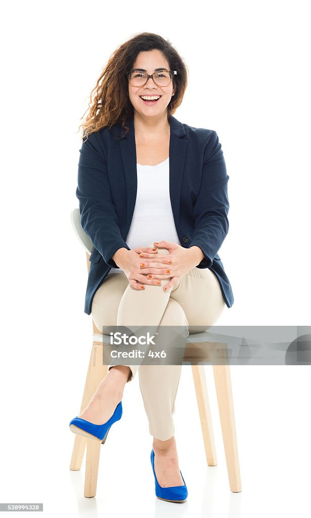 Cheerful businesswoman sitting on chair Cheerful businesswoman sitting on chairhttp://www.twodozendesign.info/i/1.png Sitting Stock Photo