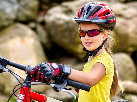 Bikes bicyclist girl. Girl with  smart watch rides bicycle into mountains. Girl wearing helmet and gloves on bicycle in mountaineering  . Mountaineering  is good for health. 