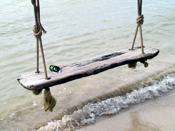 istock Swimming goggle on old wood swing, Swing over the waves 538997930