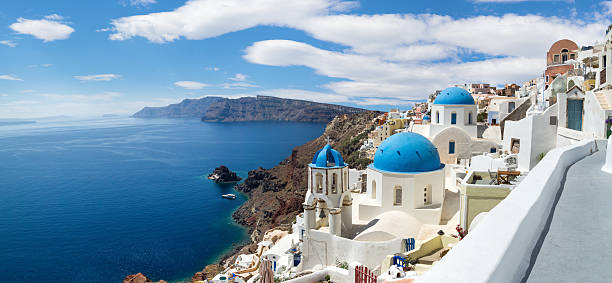 Panoramic view of the Oia village Panoramic view of the Oia village under puffy clouds, Santorini island, Greece fira santorini stock pictures, royalty-free photos & images