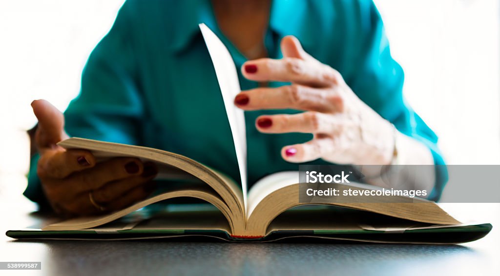 Reading Book A senior woman's hand turning the pages of a book. 2015 Stock Photo
