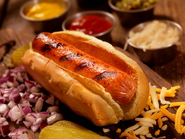 hot-dog mit allen zutaten - cheese focus on foreground on top of portion stock-fotos und bilder