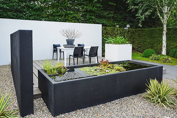 Garden with modern garden furniture and trendy pond. Appeltern, The Netherlands, July 22, 2015: The Gardens of Appeltern is the inspiration garden park in the Netherlands. In this picture a garden with modern garden furniture and trendy pond. water garden stock pictures, royalty-free photos & images