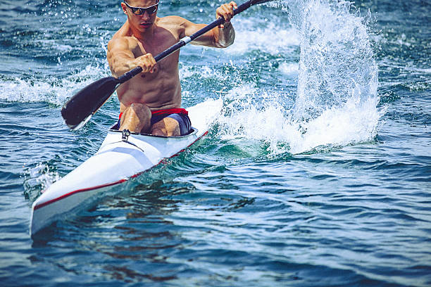 musculaire jeune homme en kayak de vitesse entraînement sur encore de l " eau. - skiff photos et images de collection