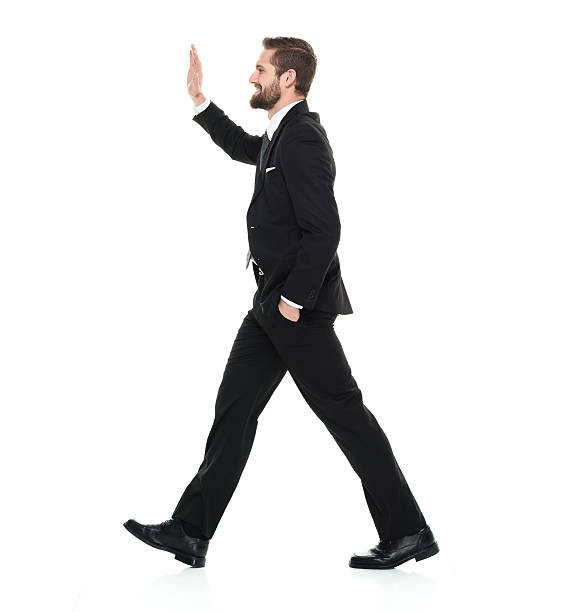 istock Smiling businessman walking and waving hand 539012222
