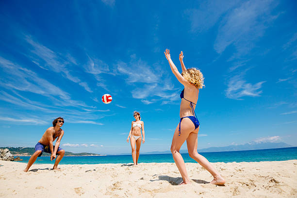 Friends playing beach volleyball on sunny summer day in bikinis and swimwear on sandy beach. Image taken with Nikon D800 and professional Nikon lens, developed from RAW in XXXL size. Location: Sithonia, Greece, South Europe, Europe.