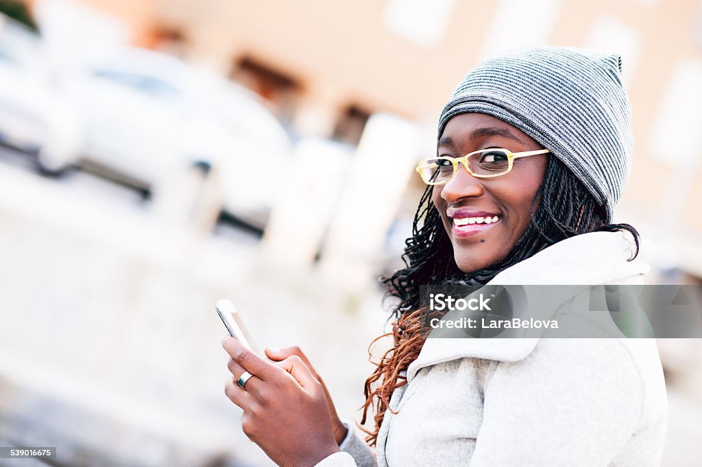 Young African woman messaging on smart phone Young African woman messaging on smart phone, selective focus. 18-19 Years Stock Photo