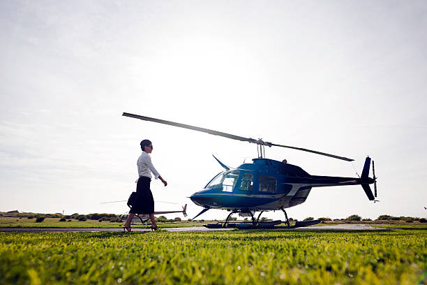 Confident business woman walking on the helipad towards the helicopter.