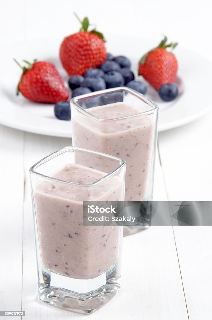 fruit smoothie in a shot glass fruit smoothie in a shot glass made from strawberries, blueberries, banana, syrup and yogurt 2015 Stock Photo