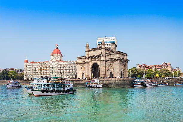 Taj Mahal Hotel and Gateway of India The Gateway of India and boats as seen from the Mumbai Harbour in Mumbai, India mumbai photos stock pictures, royalty-free photos & images