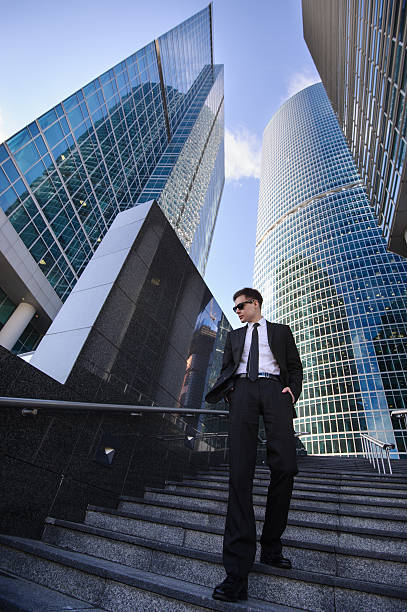istock Businessman standing on a ladder, surrounded by skyscrapers. 539019271