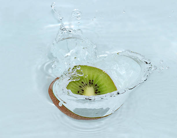 Slice of fresh kiwi falling into water