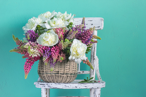 Basket with flowers peonies and lupins