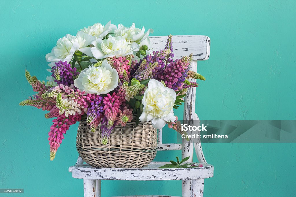 Basket with flowers peonies and lupins Flower Stock Photo