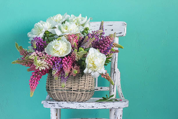 Basket with flowers peonies and lupins Basket with flowers peonies and lupins lupine flower stock pictures, royalty-free photos & images