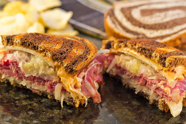 Reuben Chips Pickle Famous New York Reuben corned beef sanwich with chips and a pickle pastrami photos stock pictures, royalty-free photos & images