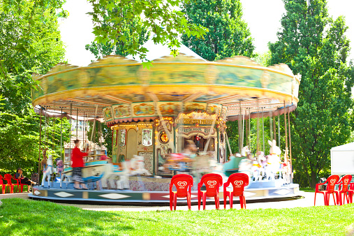Paris, France - May 20, 2009. Carousel in motion at the Parc de Bercy close to the river Seine. Two woman on the left look out for their children.