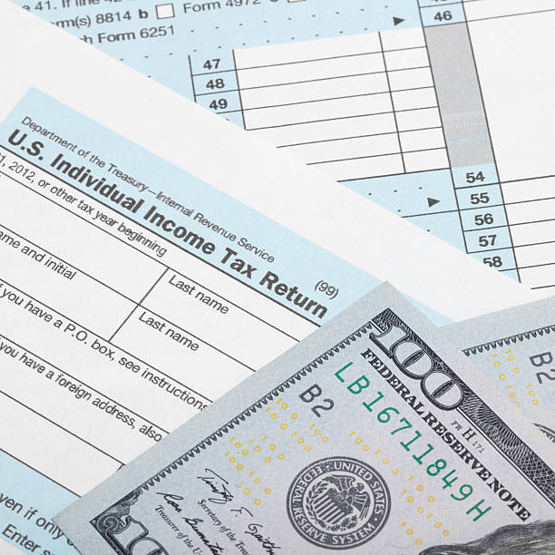 istock Hundred dollars over US 1040 Tax Form 539027019